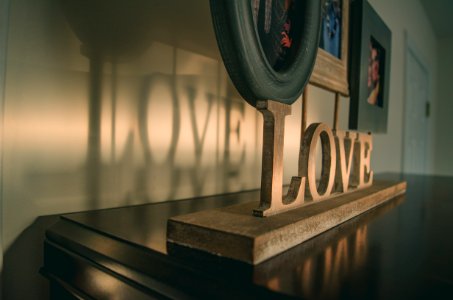 Brown Wooden Love Free Standing Letter On Black Wooden Surface photo