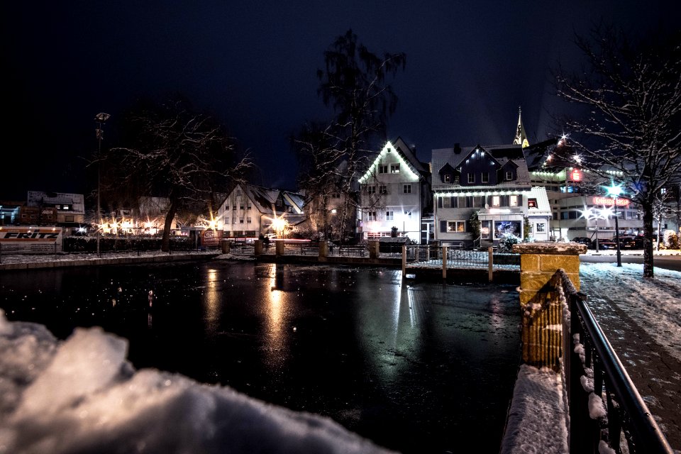 Body Of Water Infront Of White 3-storey Houses During Night Time
