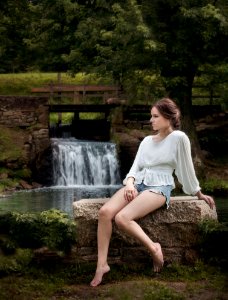 Woman Wearing White Long Sleeve Shirt Sitting Near Waterfalls