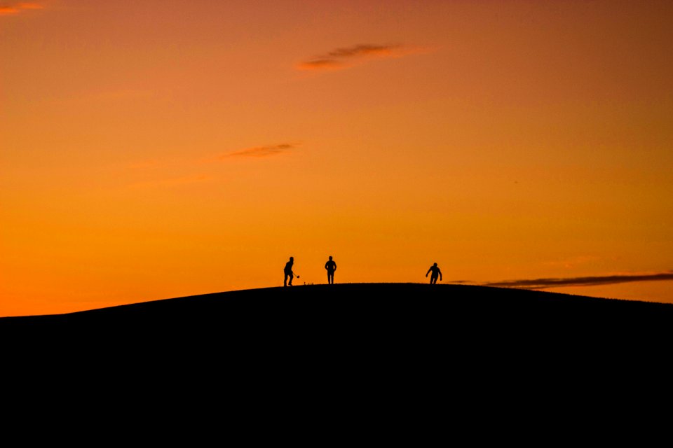 Silhouette Of 3 People In Hill During Sunset