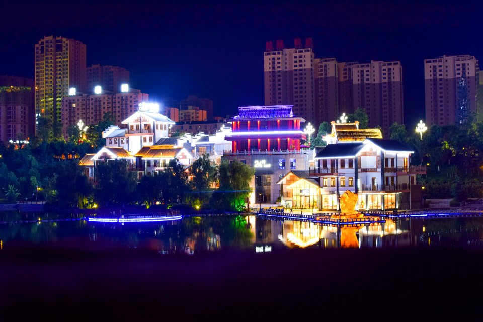 White Concrete House Beside Large Body Of Water During Nightime