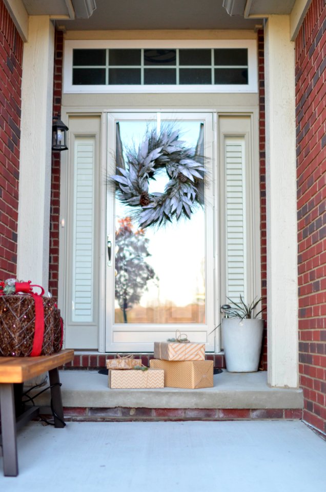 Four Brown Gift Boxes Near A Glass Paneled Door With Wreath