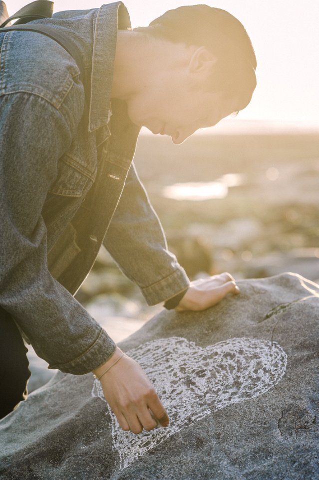Man Sketching Heart On A Gray Rock