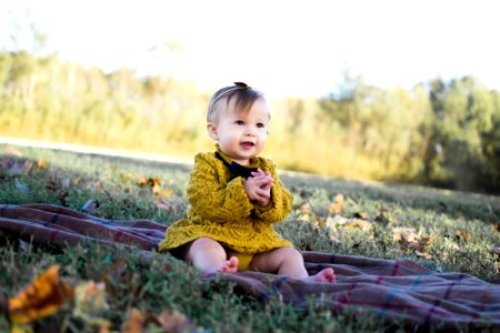 Baby Wearing Yellow Crochet Long Sleeve Dress Sitting On Brown Textile photo