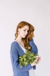 Woman In Blue Cardigan Holding Green Flowers photo