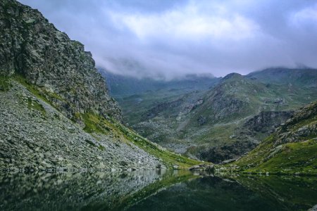 Gray And Green Mountains With Body Of Water Under Cloudy Sky photo