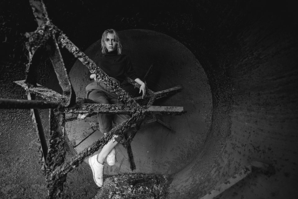 Grayscale Photography Of Woman Sitting On Bar