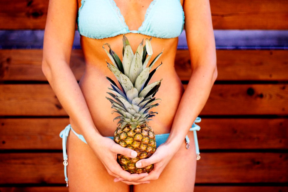 Woman Wearing Teal Bikini Holding Pineapple Fruit