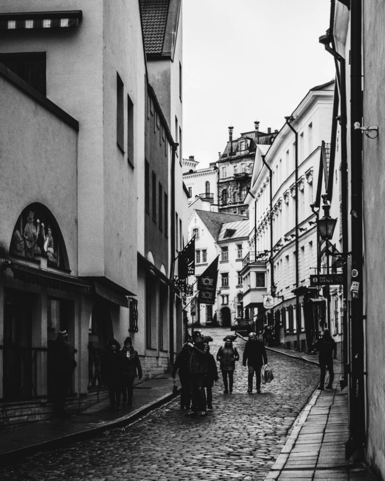 Grayscale Photo Of Group Of People Walking In Alley photo