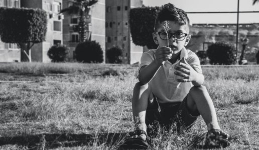 Greyscale Photo Of Boy Wearing Eyeglasses photo