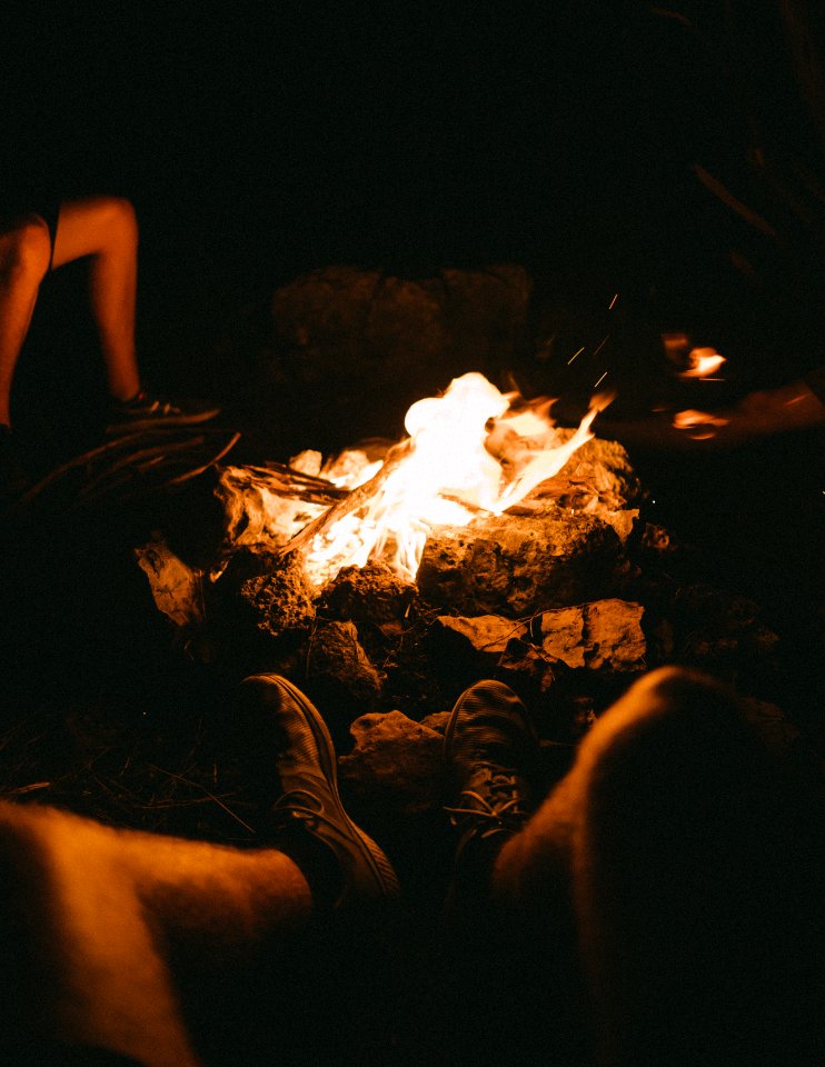 Group Of People Sitting Beside The Bonfire During Night Time