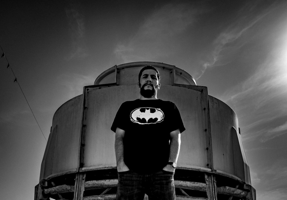 Man In Batman Print Shirt Stand Against Container photo