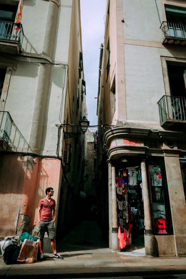 Man Wearing Red Shirt Standing Near A Concrete Structure