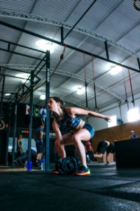 Woman Holding Adjustable Dumbbell With Her Right Hand At Gym photo