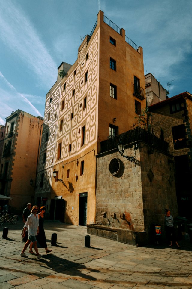 Man And Woman Walking Near Brown Concrete Building