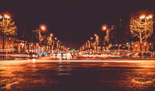 Lighted Street With Cars Passing By During Nighttime