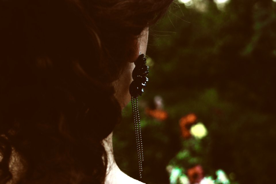 Selective Focus Photography Of Womans Back With Black Pendant Earrings photo