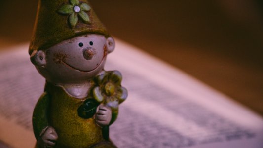Closeup Photo Of Boy Holding Flower Figurine