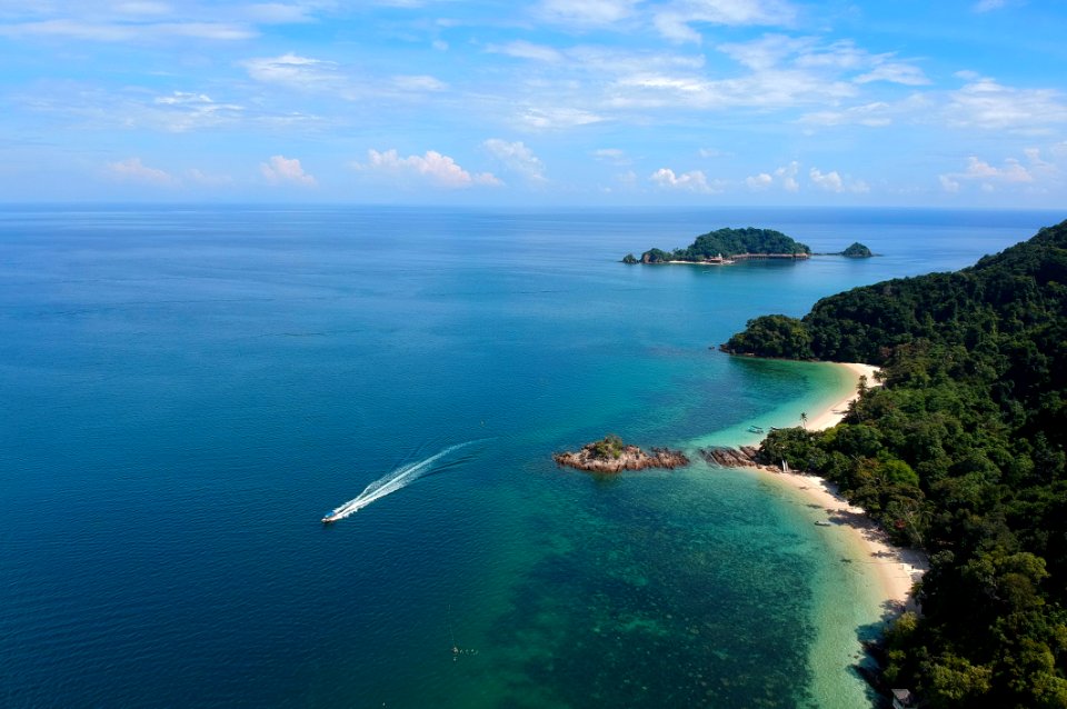 Aerial View Of White Boat Traveling Near Green Island
