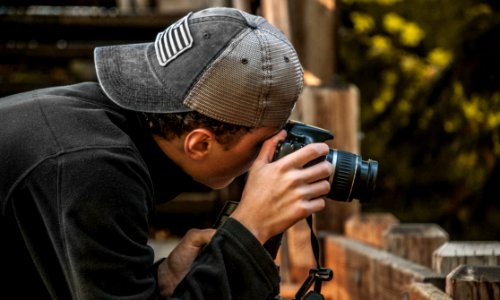 Depth Of Field Photography Of Man Holding Dslr Camera photo