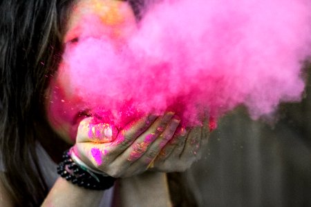 Shallow Focus Photograph Of Woman Blowing Pink Powder photo