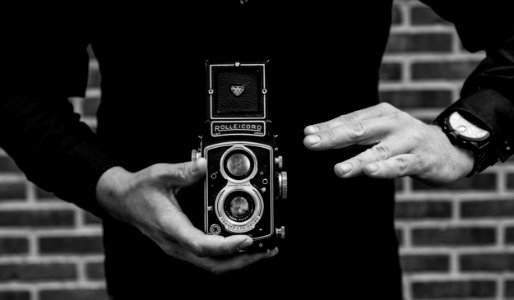 Grayscale Photography Of Man Holding Rolleicord Camera photo