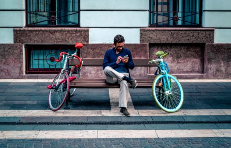 Person Sitting On Bench Between Two Road Bikes