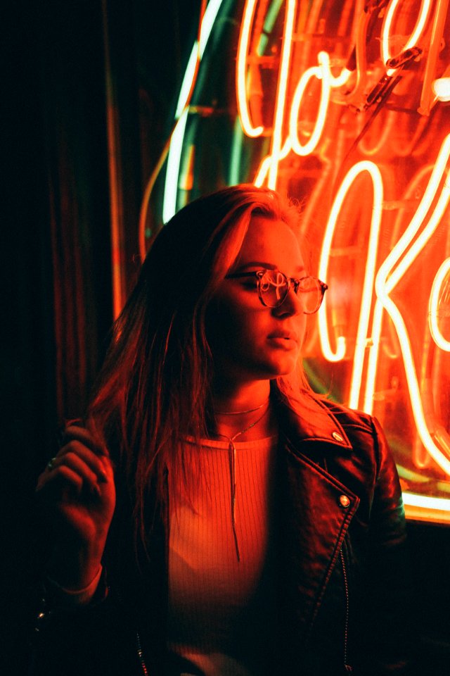 Woman In Denim Jacket Near Neon Signage