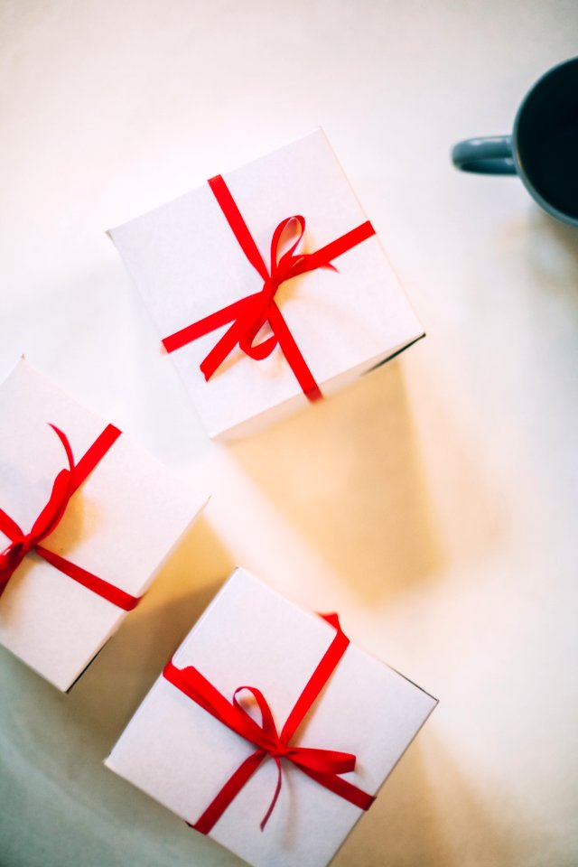 Photography Of Three Boxes With Red Ribbons