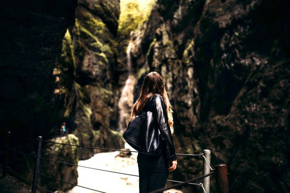 Woman In Black Leather Jacket Standing In Front Of Gray Fence photo