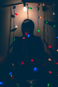 Man Sitting On Chair With Multi-colored String Lights