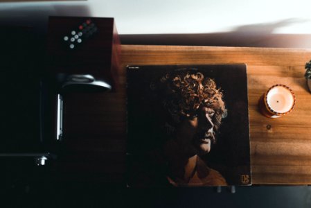 Top View Photography Of Vinyl Album Case Near White Tealight Candle Placed On Brown Table