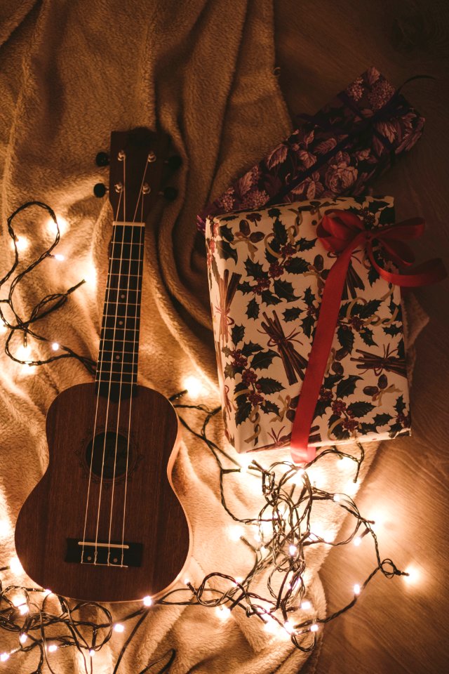 Ukulele Beside A Floral Box And String Lights