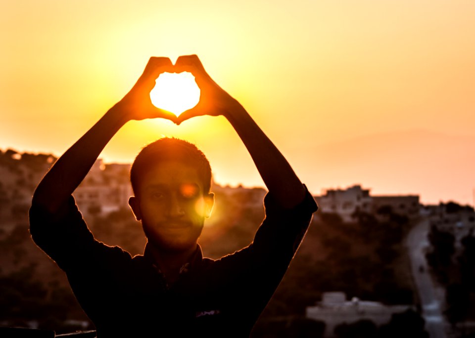 Person Making Heart Shape With His Hand During Sunset
