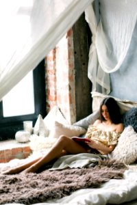 Woman Reading A Book In The Bed photo