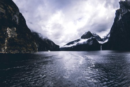 Body Of Water Surround By Mountains Under Cloudy Sky photo