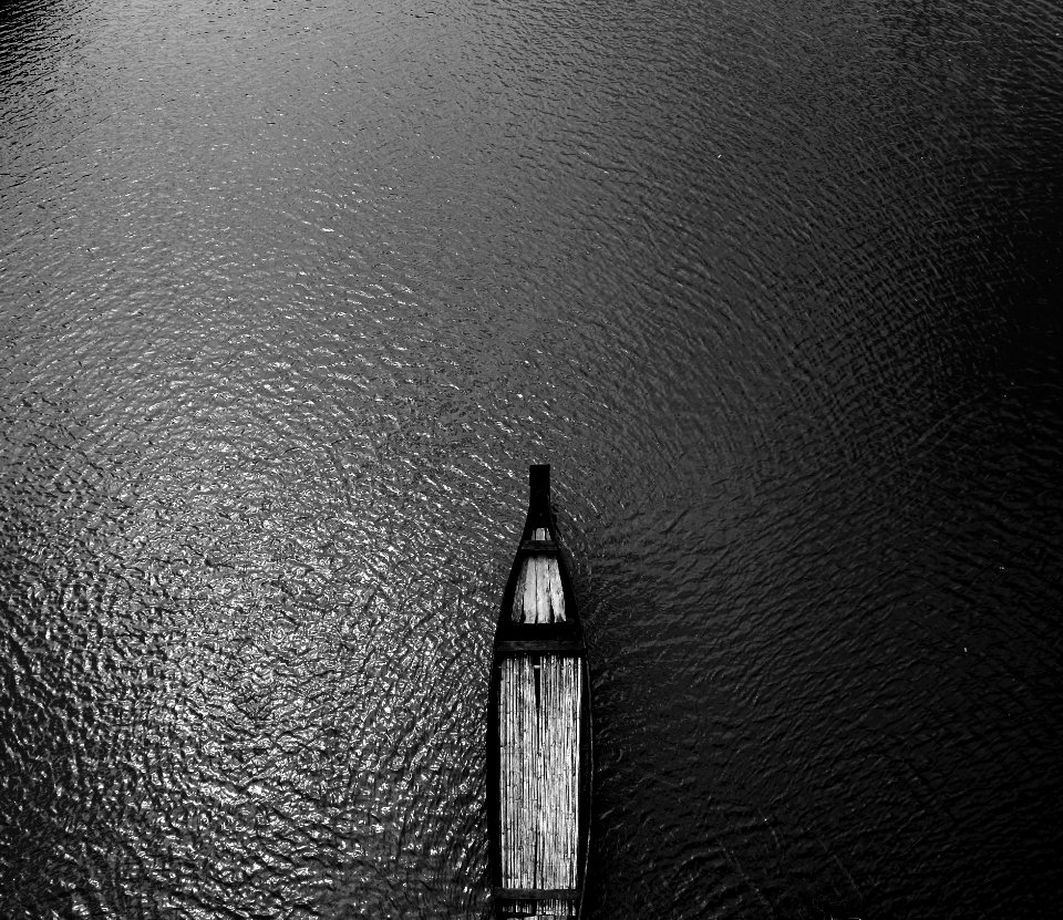 Aerial View Black Wooden Row Boat On Body Of Water