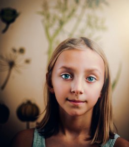 Smiling Girl Standing In White Painted Wall Room