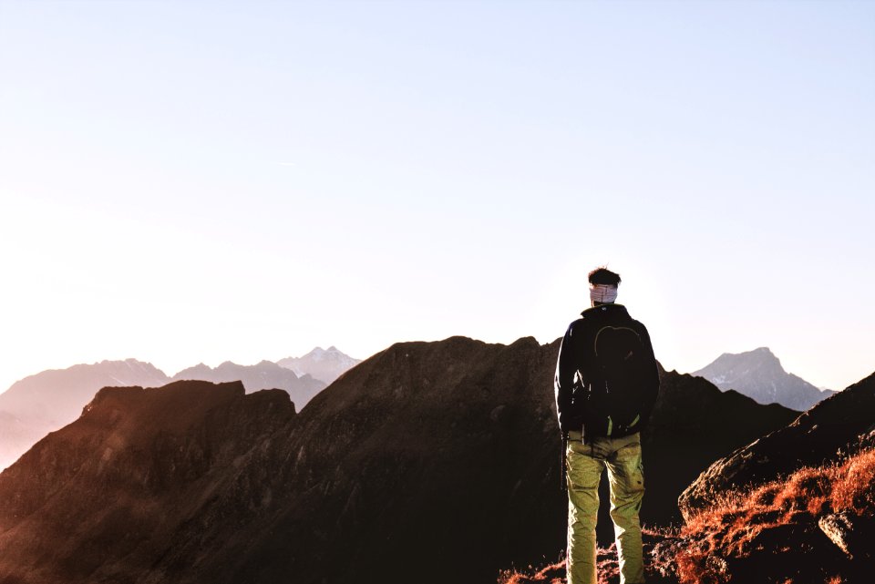 Person Standing On Top Of The Mountain