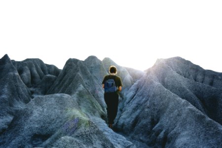 Man In Black Crew Neck Shirt And Pants Walking On Gray Mountain Formations photo