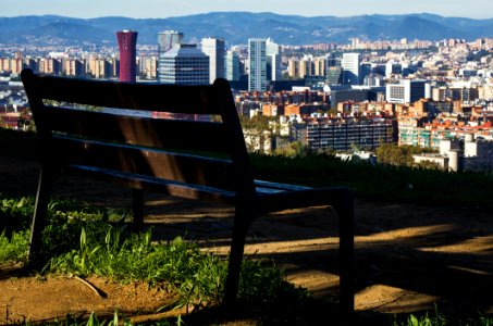 Brown Wooden Bench With Metal Frame Surrounded By Building Scenery photo