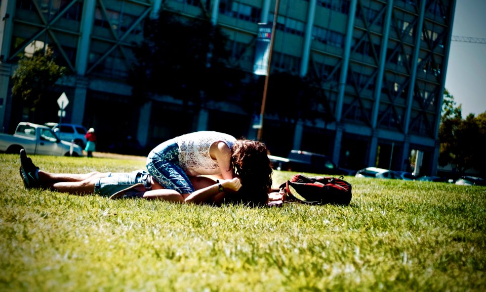 Man And Woman Lying On Green Field