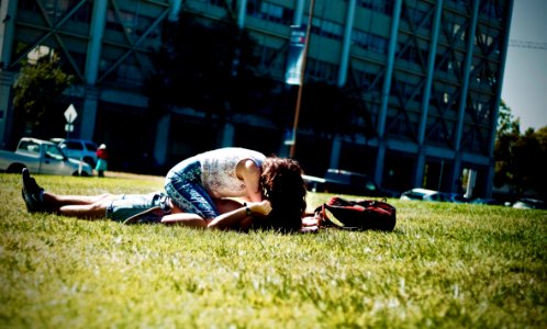 Man And Woman Lying On Green Field photo