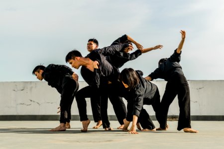 Six People In Black Matching Clothes Dancing At Daytime