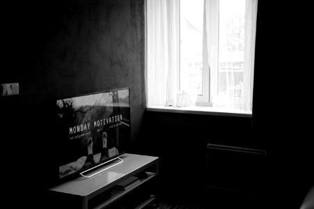 Gray Scale Photo Of Flat Screen Tv On Top Of Wooden Tv Rack photo