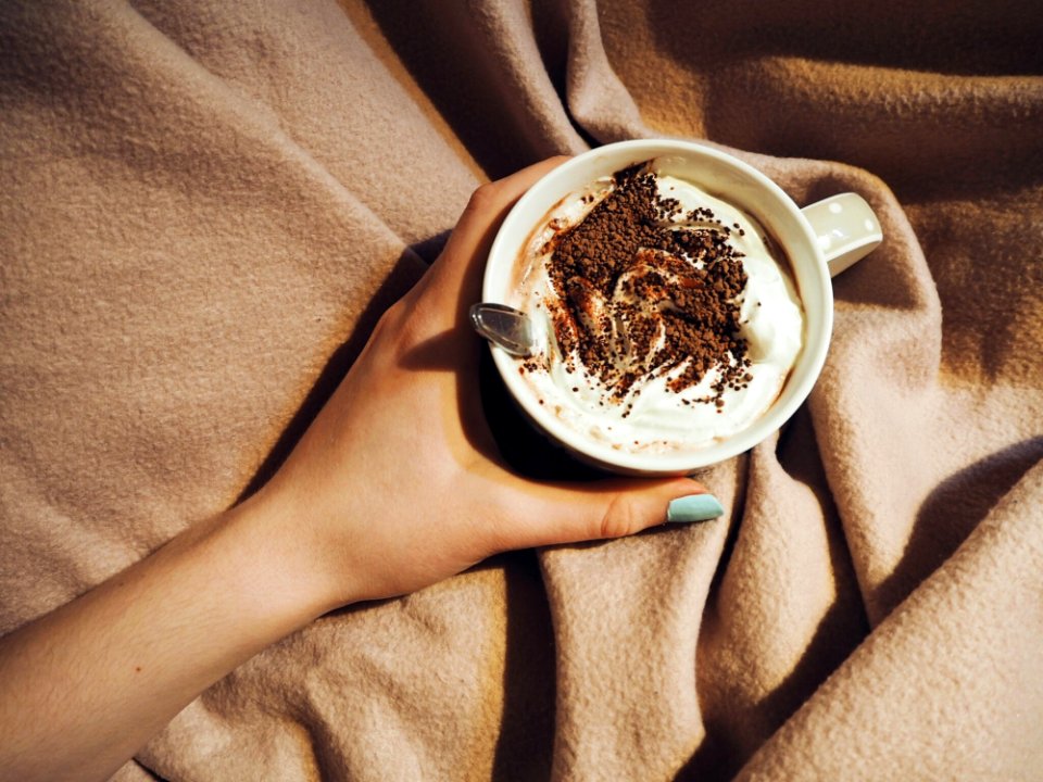 Person Holding Cup With Coffee Latte With Spoon Inside