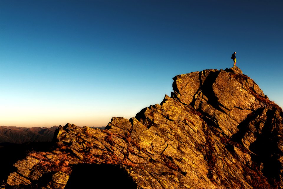 Man Standing On Top Of Rock At Daytime photo