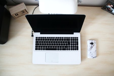 Macbook Beside Smartphone On Desk photo