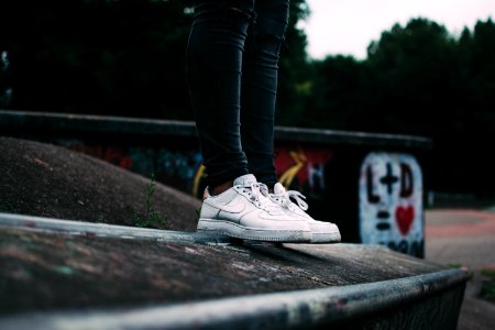 Human Standing On The Ground And Wearing White Nike Sneakers photo