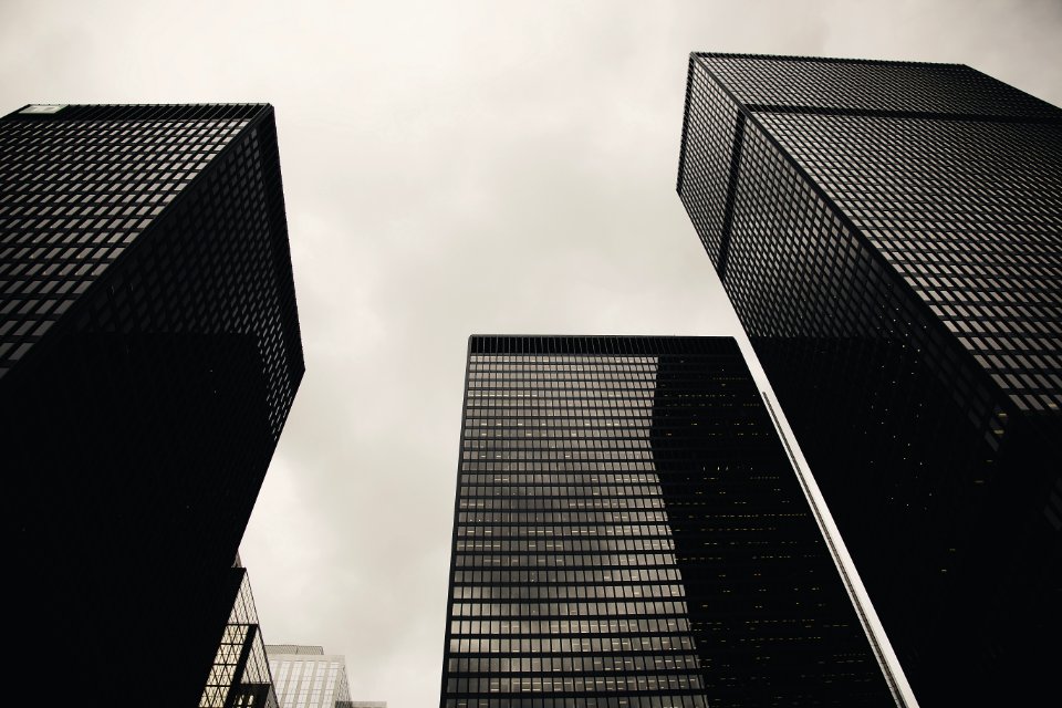 Low Angle Photography Of Black High Rise Building Under Nimbus Clouds Background photo